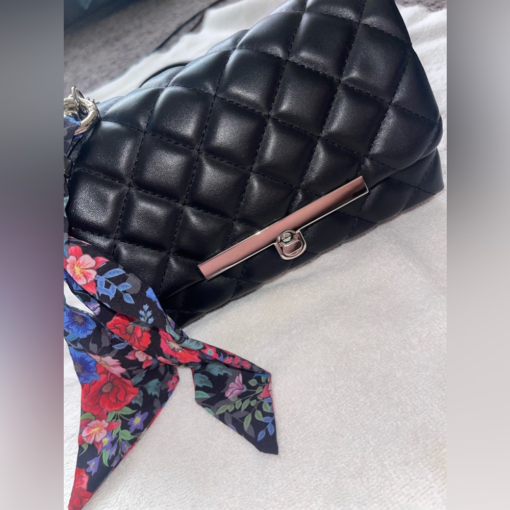 A Steve Madden crossbody black leather purse, a scarf on the side with keychain